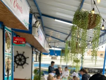 Toldo azul, timón y cartel de La Esquinita en el local